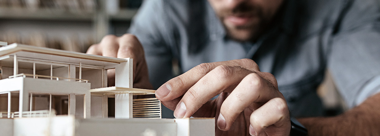 Image of architect working on scale model.